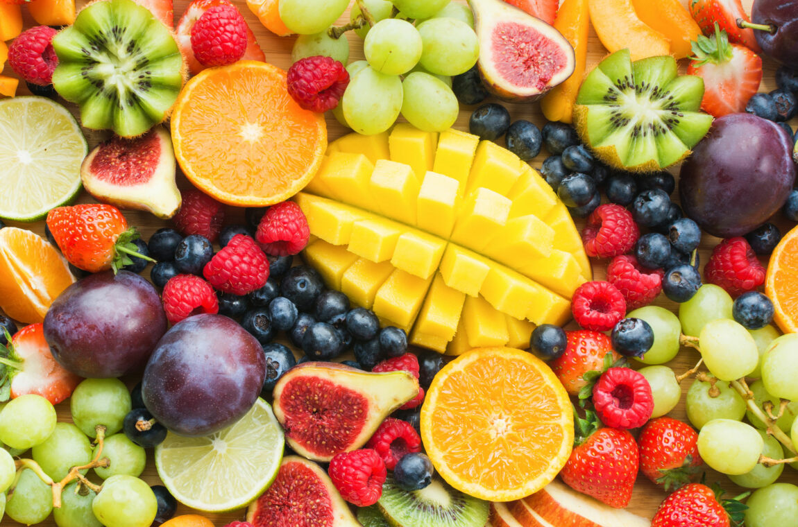 Various fruits, some of them sliced, e.g. pineapple, oranges, figs, raspberries, kiwis. Boric acid occurs naturally in almost all fruits.