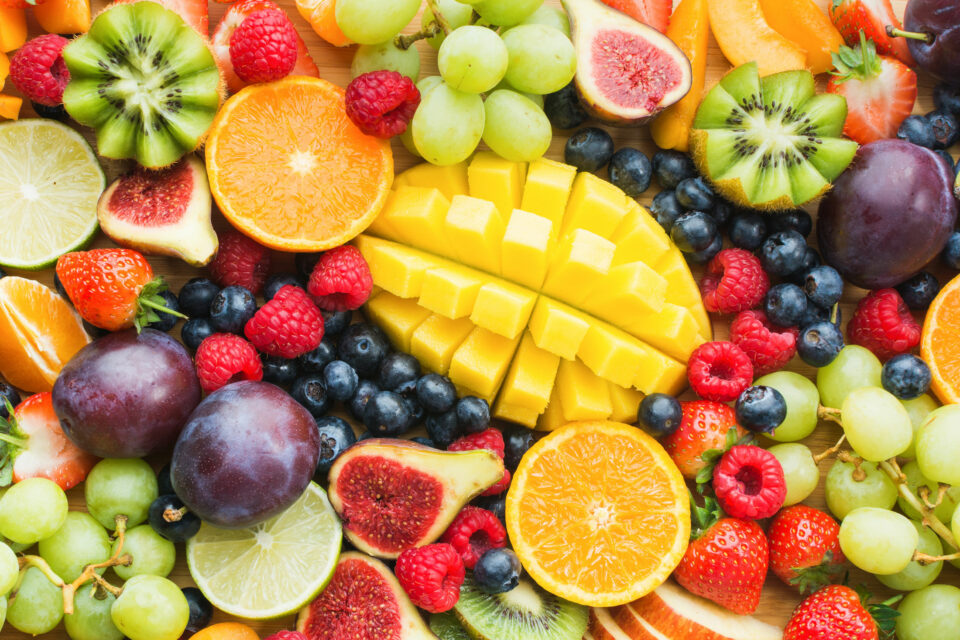 Various fruits, some of them sliced, e.g. pineapple, oranges, figs, raspberries, kiwis. Boric acid occurs naturally in almost all fruits.
