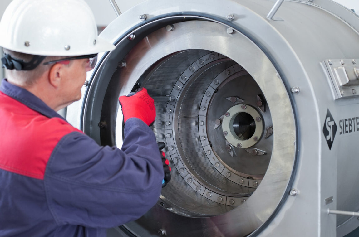 Centrifuge service / maintenance. Fitter replaces slotted screens